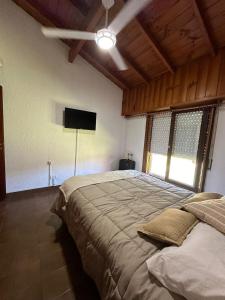 Un dormitorio con una cama grande y un televisor de pantalla plana. en Cuidamos tu casa, en Villa Gesell