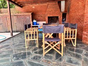 un patio con sillas, una mesa y una pared de ladrillo en Cuidamos tu casa, en Villa Gesell