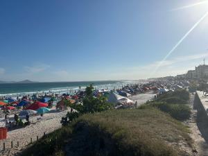 a beach with a bunch of umbrellas and the ocean at RoseMarAzul Temporadas in Cabo Frio