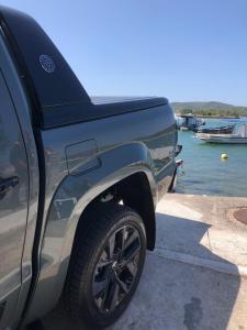 a truck parked next to the water with a boat at RoseMarAzul Temporadas in Cabo Frio +2 photos