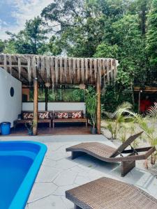 drewniana pergola i basen na dziedzińcu w obiekcie Pousada AimeMaresias - Loft - Seu Paraíso - 8min da Praia w mieście São Sebastião