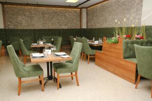 a restaurant with wooden tables and green chairs at Golden Lounge Hotel in Istanbul