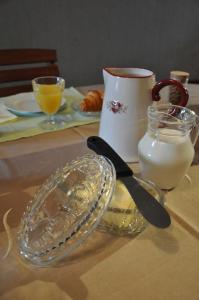une table avec une plaque de verre et un pichet de lait dans l'établissement Les Charmilles, à Saint-Jean-de-Losne