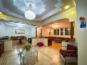 a living room with a ceiling with a chandelier at Appartement Spacieux au Centre in Chefchaouene