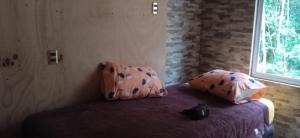 une chambre avec un lit avec deux oreillers dessus dans l'établissement RioBlanco Lemu Leufu 1, à Hornopirén