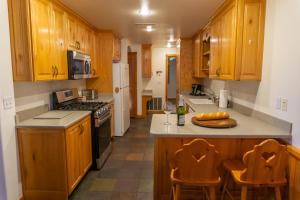 una cucina con armadi in legno e bancone con due sedie di Family Vacation-Heated In Out Pool, Tubing & Ice Skating 719 townhouse a Midway