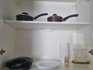 two pots on a shelf in a kitchen at apartment work centro in Ubá