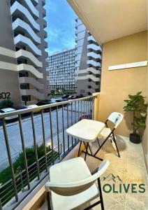 a balcony with a table and chairs and a view of the ocean at Curated Stay Near Airport - Mount Olives in Lapu Lapu City
