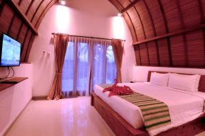 a bedroom with a large bed and a television at Ubud 3-bedrooms with sunset view in Ubud