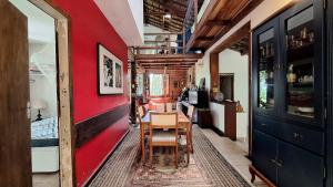 une salle à manger avec des murs rouges, une table et des chaises dans l'établissement Casa em meio a natureza - Ideal para casal, à Rio de Janeiro