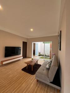 a living room with a couch and a flat screen tv at Tera Bali Villa Bedugul in Buleleng