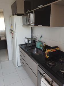 a small kitchen with a sink and a refrigerator at Ap no centro do Vila Branca in Jacareí +4 photos
