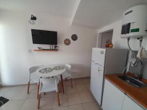 a kitchen with a small table and a white refrigerator at Los Paraísos Oro Verde in Oro Verde