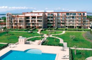 un complejo con piscina y un gran edificio en Résidence Les Flamants Roses, en Canet-en-Roussillon