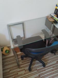 a desk and a chair in a room with a mirror at Ap no centro do Vila Branca in Jacareí