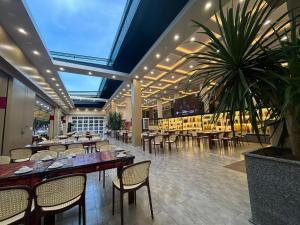 a restaurant with tables and chairs and a potted plant at Khách Sạn Đối Ngoại Biên Phòng in Buon Ma Thuot