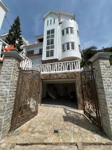 头顿Trần Phú Homestay Vũng Tàu - View biển bãi trước - 7 phòng ngủ lớn - Hồ bơi riêng的前面有大门的白色大房子