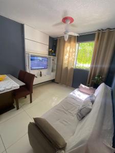 a bedroom with a large bed and a television at Apartamento da Letícia in Camaçari