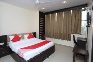 a bedroom with a bed with red pillows and a window at Super Collection O R K International Near Gautam Buddha Park in Lucknow