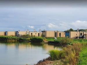 un fiume con edifici sullo sfondo accanto a un fiume di Chalet Meeresruhe Comfortable holiday residence a Enkhuizen