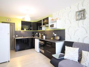 kuchnia z czarnymi szafkami i białą ścianą w obiekcie F3 avec Wifi à 150m du centre et thermes du Mont-Dore - 5 couchages - FR-1-415-143 w mieście Mont-Dore