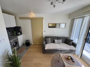 salon z kanapą i stołem w obiekcie Charmant 2 pièces à 2 pas de la plage avec loggia - tout confort - FR-1-712-9 w mieście Villers-sur-Mer