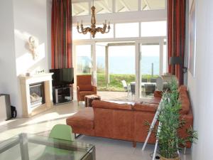 a living room with a couch and a fireplace at Dijkvilla on the IJsselmeer in Makkum +16 photos
