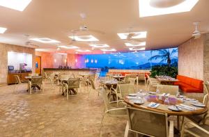 ein Restaurant mit Tischen und Stühlen in einem Raum in der Unterkunft Hotel Irotama del Sol in Santa Marta