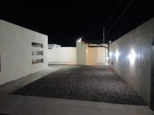 une allée vide la nuit avec des murs et des lumières blancs dans l'établissement Casa VistaBella, à San Felipe