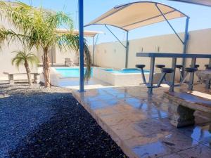 un patio avec une table de pique-nique et une piscine dans l'établissement Casa VistaBella, à San Felipe