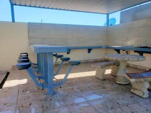 une chambre avec une table bleue et quelques bancs dans l'établissement Casa VistaBella, à San Felipe