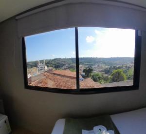 a window in a room with a view of a roof at Zuppolini Garden Hotel in Bananeiras