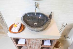 un lavabo noir sur un comptoir dans une salle de bain dans l'établissement Jayendra House Ubud, à Ubud 38 autres photos