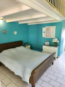 Bett in einem Zimmer mit blauer Wand in der Unterkunft Droomstudio seru coral 32 in Willemstad