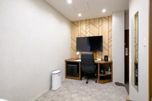 a room with a desk with a chair and a television at ホテル　サンシャインとうはく in Yabase