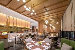 un ristorante con tavoli e sedie e un bar di Hilton Garden Inn Ordos Kangbashi a Ordos