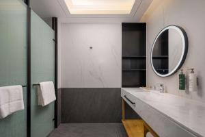 un bagno con lavandino e specchio di Hilton Garden Inn Ordos Kangbashi a Ordos Altre 24 foto