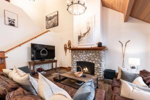 een woonkamer met banken en een open haard bij Montebello 4877 by Outpost Whistler in Whistler