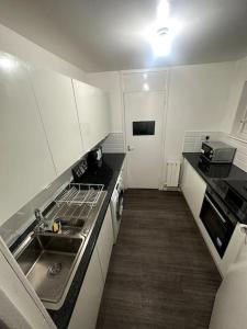 a small kitchen with a sink and a stove at Urban Oasis with Private Terrace in London