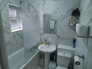 a white bathroom with a sink and a toilet at Urban Oasis with Private Terrace in London +6 photos