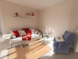 un salon avec un canapé et une chaise dans l'établissement Bel appartement 4 pers avec parking et WIFI au centre-ville de Perros-Guirec - FR-1-368-454, à Perros-Guirec