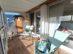 une chambre avec un balcon avec des chaises et une fenêtre dans l'établissement Bel appartement 4 pers avec parking et WIFI au centre-ville de Perros-Guirec - FR-1-368-454, à Perros-Guirec