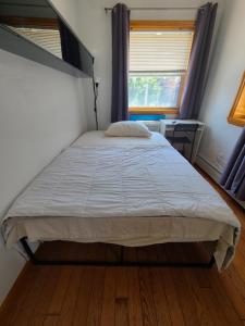 a large bed in a bedroom with a window at Nice rooms Woodside in Queens