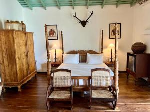 a bedroom with a bed and two wicker chairs at Villa Seven Faces-Luxury Escape,Stunning Views with Private pool for a Couple or family! in Galle