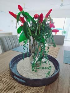 a vase with red flowers in it on a table at Skyview 2 bathroom Sub-Penthouse Harbour Views in Darwin +39 photos