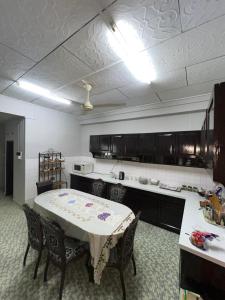 a kitchen with a table and chairs in a room at Seri Selasih Klebang! in Malacca +9 photos