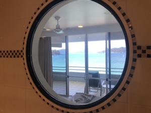 a mirror in a room with a view of the ocean at Frangipani 206 beachfront apartment in Hamilton Island