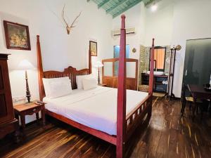 a bedroom with a four poster bed and a desk at Villa Seven Faces-Luxury Escape,Stunning Views with Private pool for a Couple or family! in Galle