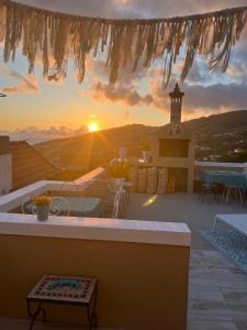 a view of a sunset from a patio with a table at CASA BOHO your happy place in Calheta in Calheta