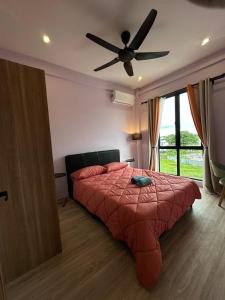 a bedroom with a bed with a ceiling fan at Sleek Cottage GLEN 1 HomeStay Kuching in Kuching +2 photos